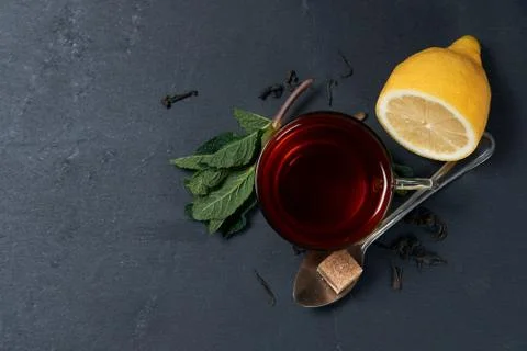 Black tea with mint and lemon on a dark background with copy space Stock Photos