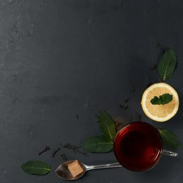 Black tea tea with mint and lemon on a dark background Stock Photos