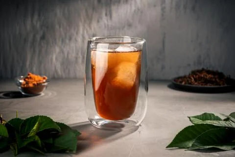 Black tea with tea tree leaves in a double-walled glass Cup Stock Photos