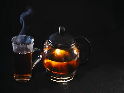 Black tea in a transparent teapot tea in glass Cup on black background Stock-Footage 73954576