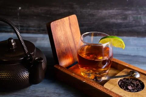 Black tea on a vintage background, for a hot day, organic with a bottle Stock Photos