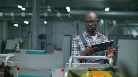 Black Technician Using Digital Tablet to Control Machinery in Printing House Vídeos de archivo 335482953