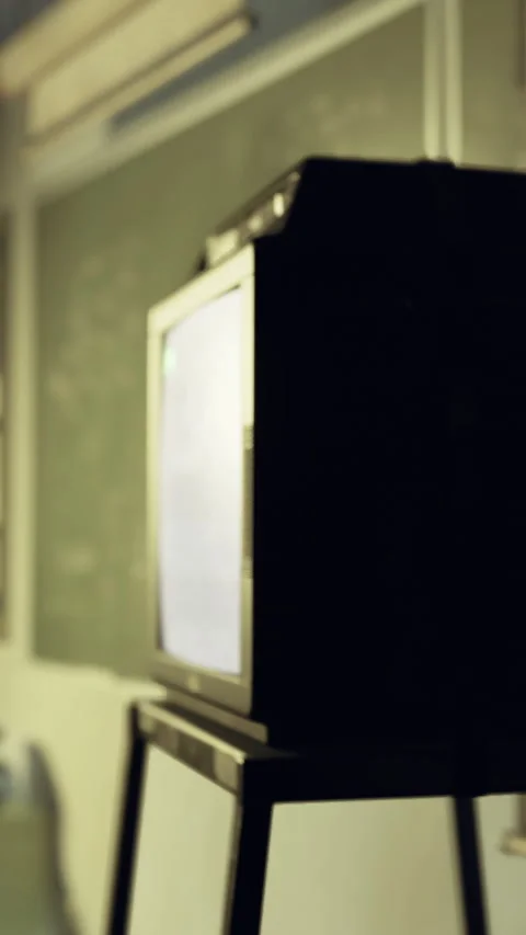 Black television on a stand in a classroom setting during a learning session Stock Footage 330449544