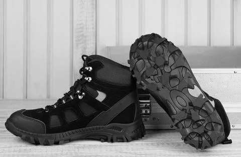 Black textile work boots for safe winter,steel cap,non-slip sole on gray boards Foto stock