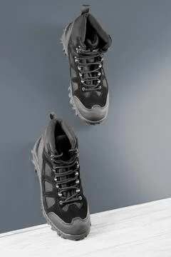 Black textile work boots for safe winter,steel cap,non-slip sole on metal wall Stock Photos