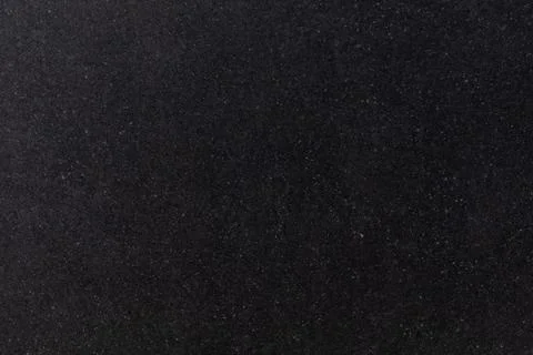 Black textured surface with fine particles in a dark setting, suitable for Stock Photos