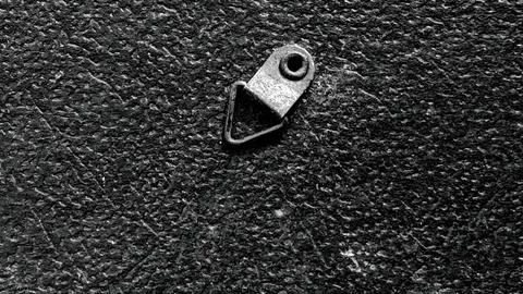 Black Textured Surface with Metal Triangular D Ring Picture Hanger 스톡 사진