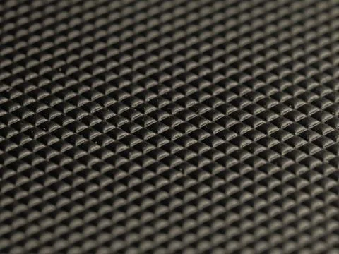 Black textured surface with repeating geometric pattern Stock Photos