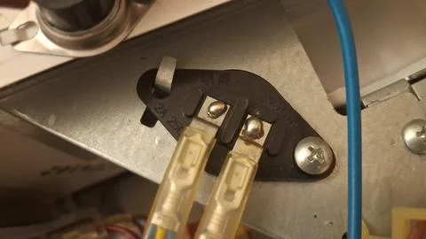 Black thermal fuse component mounted inside an industrial electrical appliance Stock Photos