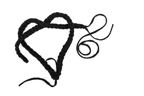 Black thread crochet chain layed in the shape of a heart isolated on white .. Stock Photos