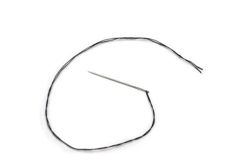 Black thread in a needle on a white background Foto stock