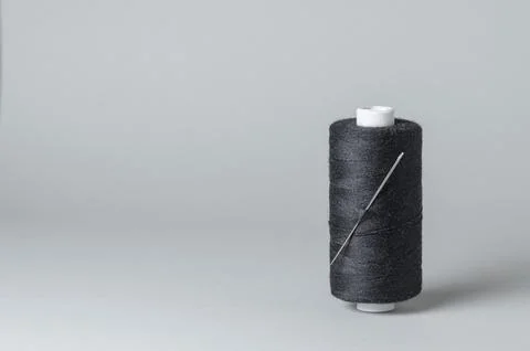 Black thread spool with needle close-up Stock Photos
