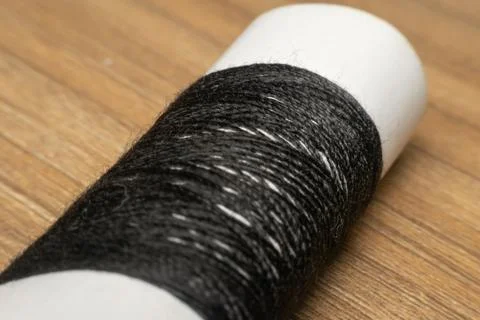 Black Thread Spool On Wooden Surface Foto stock
