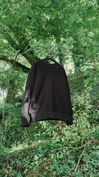 Black Tie-Dye Pattern Sweatshirt Mockup Hanging in a Forest Stock-Fotos