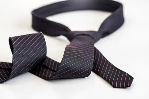 Black tie knotted in a loop shape on a white background. The concept of not f Stock Photos