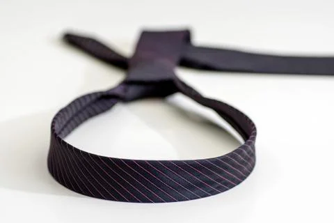 Black tie knotted in a loop shape on a white background. The concept of not f Stock Photos