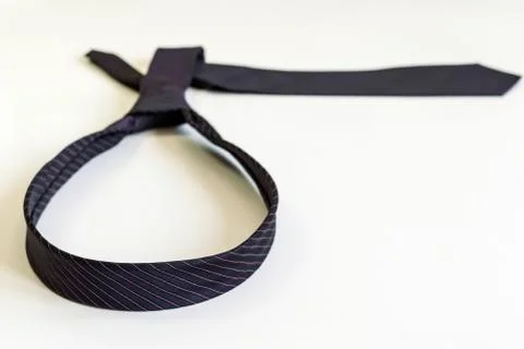 Black tie knotted in a loop shape on a white background. The concept of not f Stock Photos