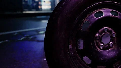 Black tire rests on wet pavement in urban area at night Stock Footage 342801705