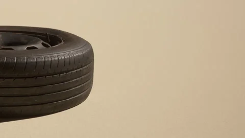 Black tire on a sandy surface with light shadows in the background Stock Footage 342809506