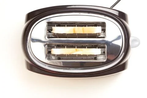 Black toaster, two slices of bread inside Stock Photos