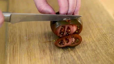 Black tomato cutting with a sharp knife 스톡 동영상 171980142