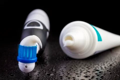 Black toothbrush with toothpaste on black Фото