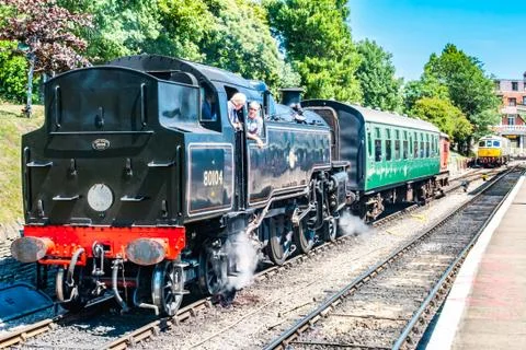Black train with conversation between driver and guard Stock Photos