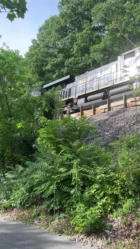 Black train going in and out of frame down train tracks Video stock 197133139
