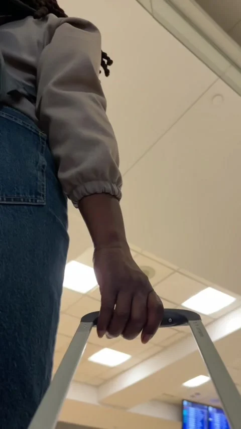 Black traveller pulling a suitcase through an airport Stock-Footage 337857840