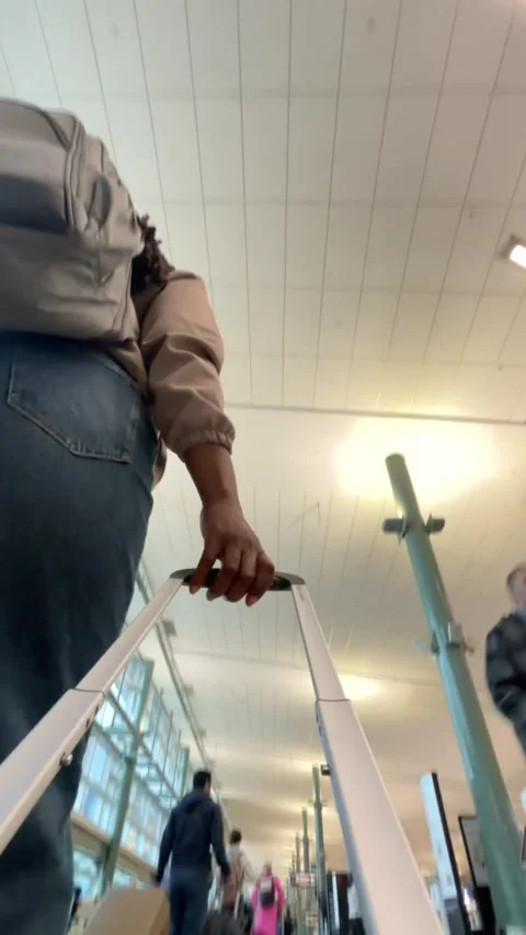 Black traveller pulling a suitcase through an airport Video stock 337857843