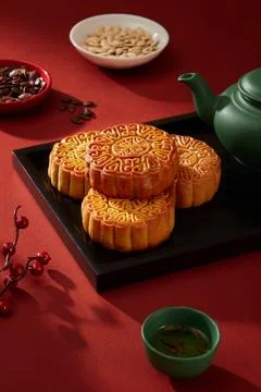 Black tray in rectangle shaped featured some mooncakes and green teapot. Smal Foto stock
