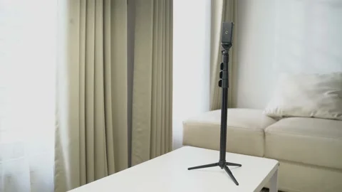 A black tripod standing on a white table in the living room Video stock 163863197