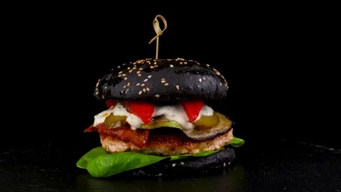 Black Turkey Burger with grilled vegetables on black stone tray Stock Footage 84652786