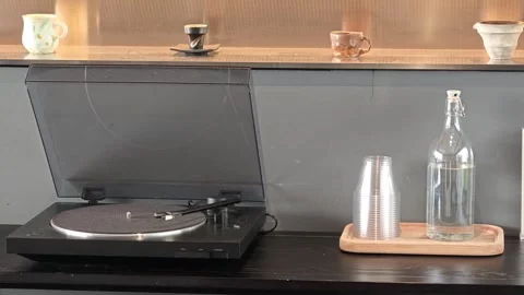 Black turntable and ceramic coffee ware arranged on minimalist wooden shelves Stock-Footage 344746740