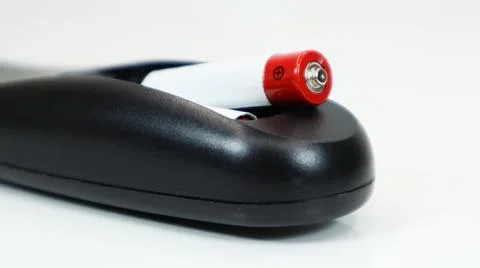 Black TV remote control with AAA alkaline batteries on a white background. Ba Foto stock