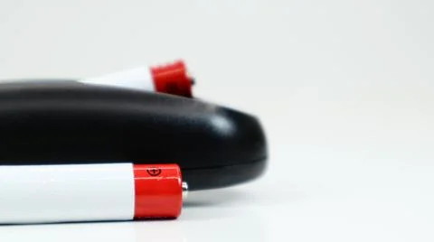 Black TV remote control with AAA alkaline batteries on a white background. Ba 写真素材