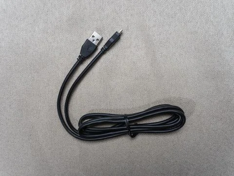 Black twisted usb cable for Sony PlayStation console on the table 07 04 2019 Stock Photos