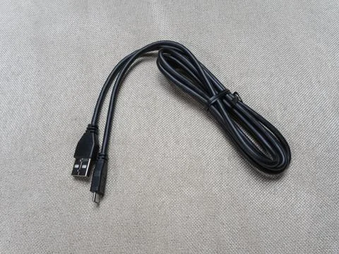 Black twisted usb cable for Sony PlayStation console on the table 07 04 2019 Stock Photos
