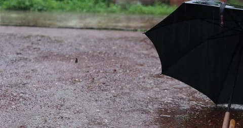 A Black umbrella opens outdoors during heavy rainfall. Vídeos de archivo 342397639