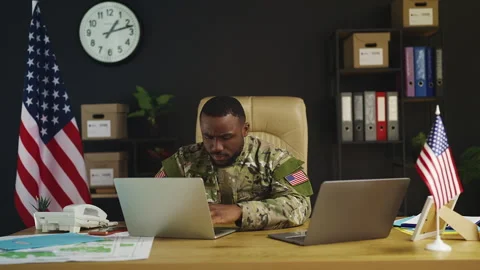 Black U.S. intelligence officer works on laptops in office, planning mission Stock Footage 342149349