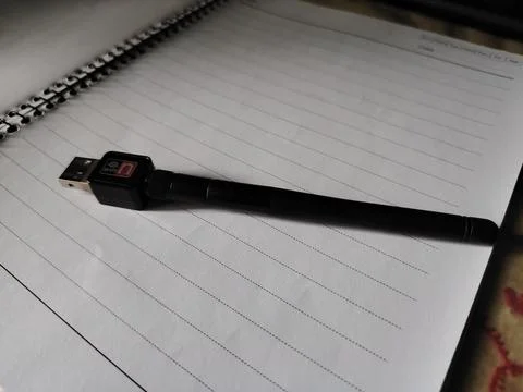 Black usb cable lying on a spiral lined notebook page Fotos Stock