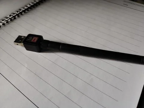 Black usb cable with red and white logo on notebook page with lined paper Fotos Stock
