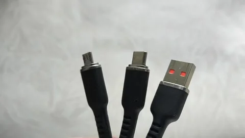 A black USB charging cable in the hand. The cable has a standard USB connector Stock Footage 317668291