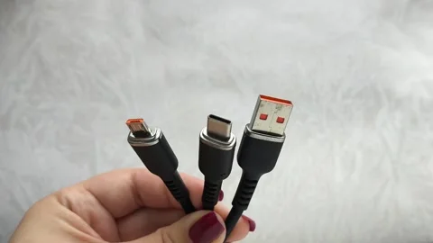 A black USB charging cable in the hand. The cable has a standard USB connector Stock Footage 317668330