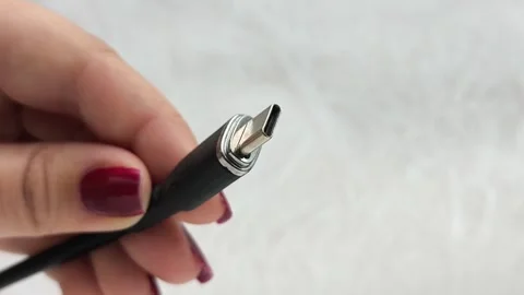 A black USB charging cable in the hand. The cable has a standard type-c Video stock 317668526