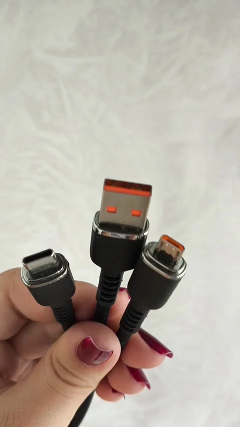 A black USB charging cable in the hand. The cable has a standard USB connector Stock Footage 317668745