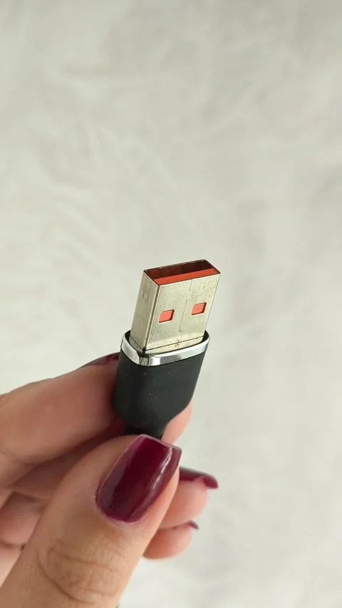 A black USB charging cable in the hand. The cable has a standard USB Stock Footage 317668829