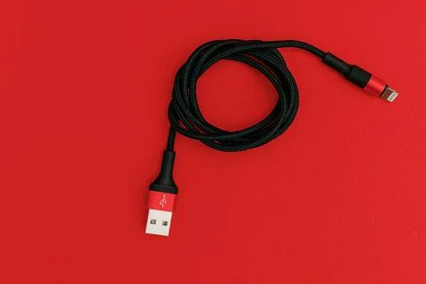Black usb cord on red background, subject technology Stock Photos