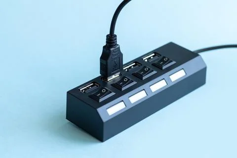 Black USB hub with usb cable plug on blue background Stock Photos