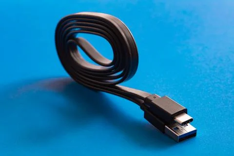 Black USB Type-C cord on blue background Stock Photos